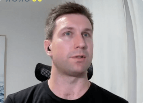 Man with short hair wearing a black shirt, headset.