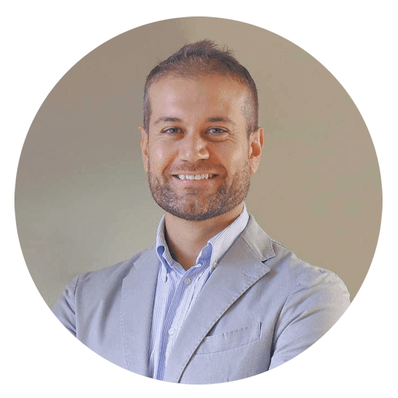 Smiling man in a light gray suit jacket.