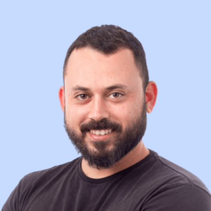 Man with beard smiling, wearing black shirt.
