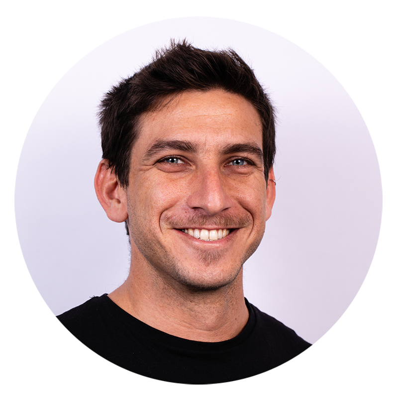 Man smiling in front of plain background.