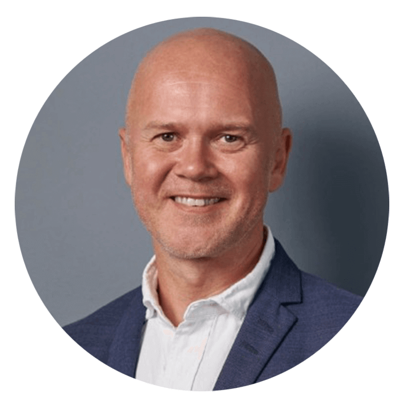 Smiling bald man in blue blazer and white shirt.