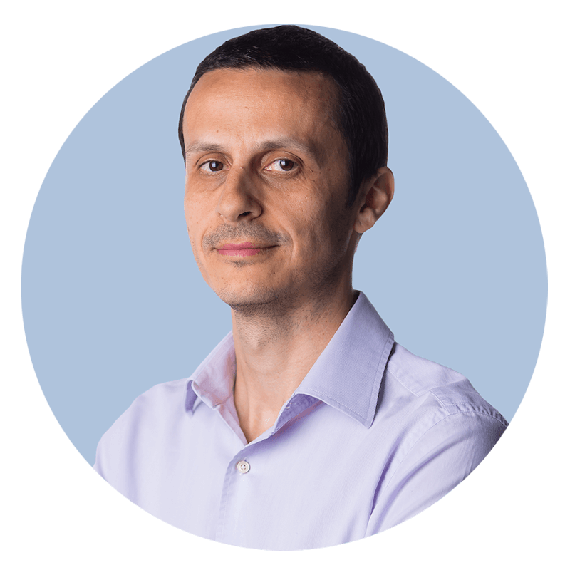 Man in light purple shirt, blue background.