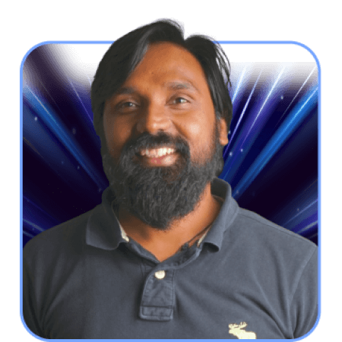 A bearded man smiling against dark abstract background.